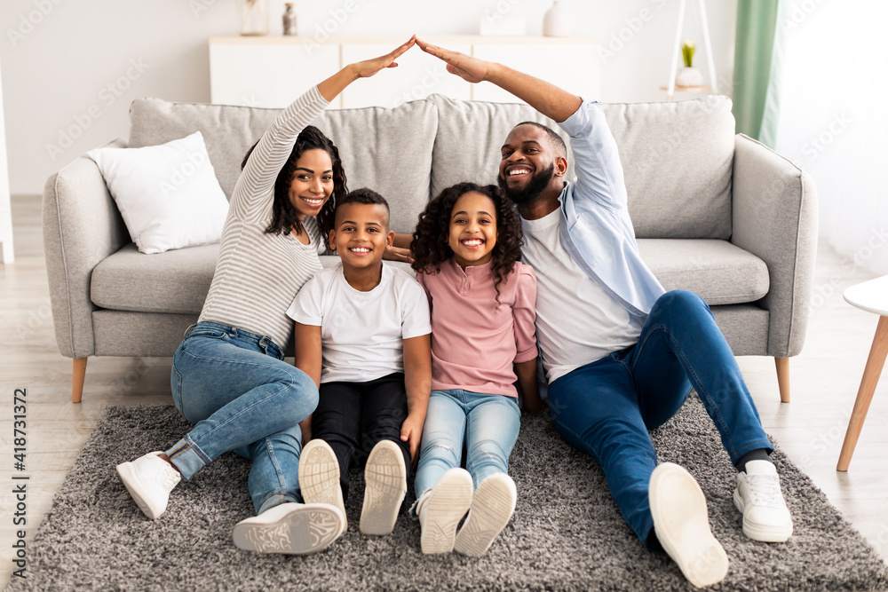 © Prostock-studio - Black parents making symbolic roof of hands above their children