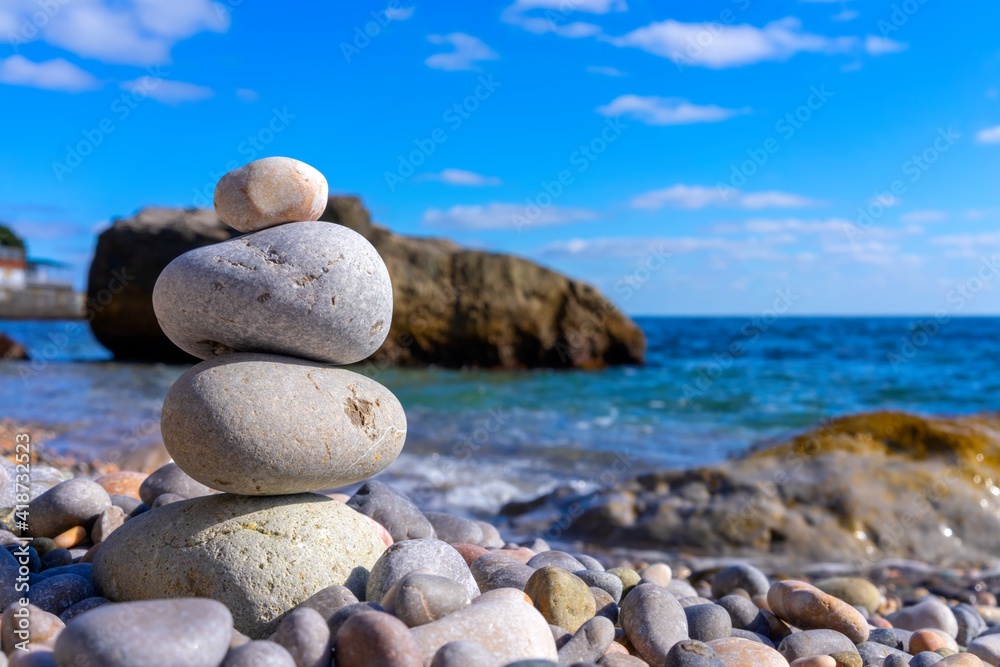 Man-built pyramid of four stones of sea pebbles at a seaside resort Man-built pyramid of four stones of sea pebbles at a seaside resort