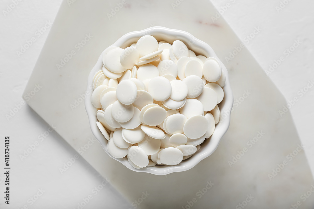 Bowl with chocolate drops on light background Bowl with chocolate drops on light background
