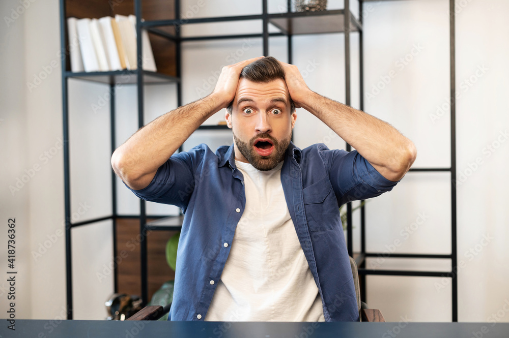 American shocked businessman receiving unexpected news, touching his head with round eyes, being surprised, got message, won in the lottery, excited by news, invited on a date, got a promotion at work American shocked businessman receiving unexpected news, touching his head with round eyes, being surprised, got message, won in the lottery, excited by news, invited on a date, got a promotion at work