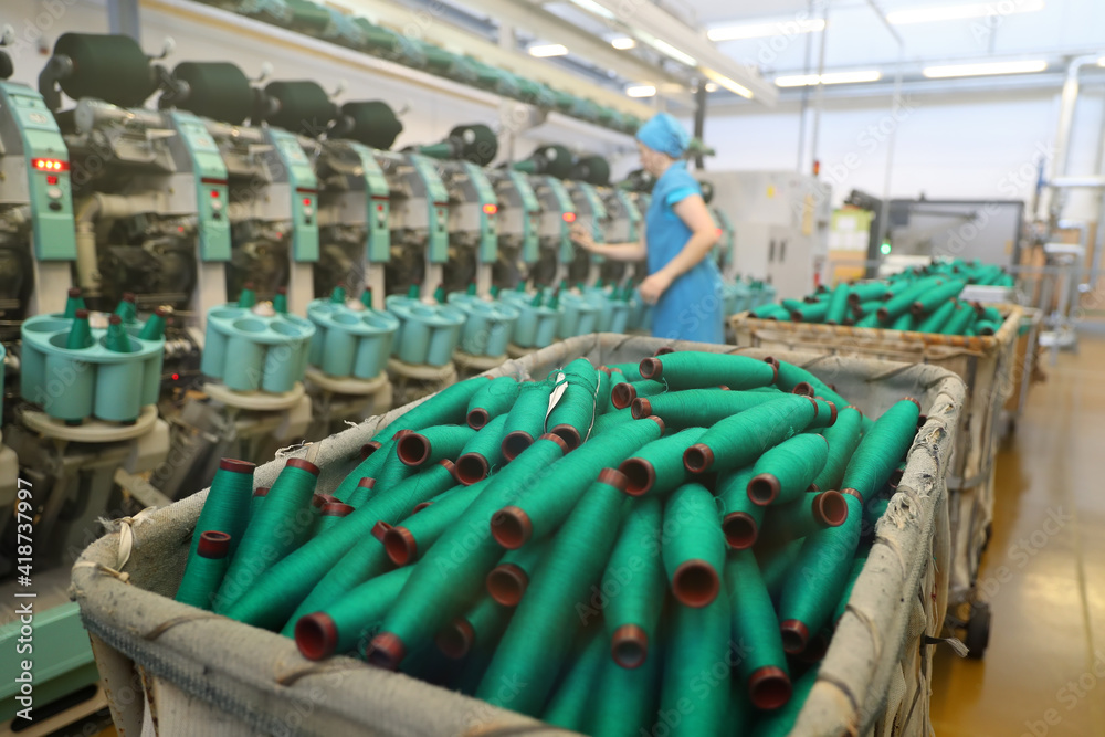 Obraz premium Close-up of the produced threads against the background of the production line. Factory for the production of threads and fabrics