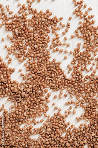 Buckwheat is randomly scattered on a white background. Top view. Copy, empty space for text