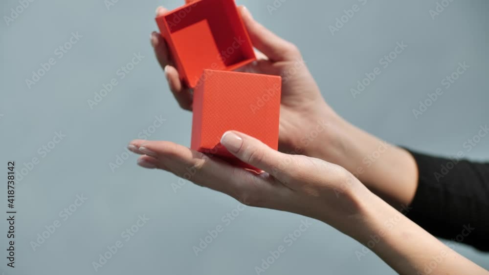 the girl has a beautiful gift box with a surprise in her hands, which she opens