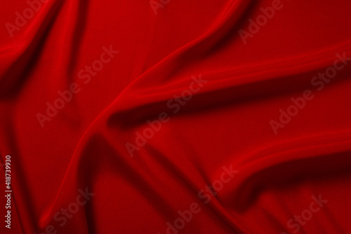 Red silk or satin luxury fabric texture can use as abstract background. Top view.