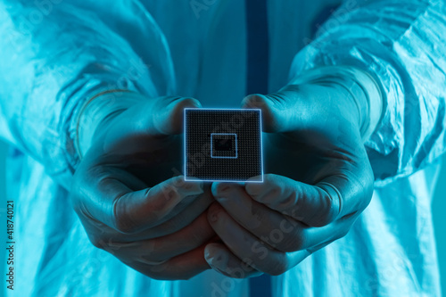 Foto Microprocessor in hands in latex gloves in a sterile suit close-up
