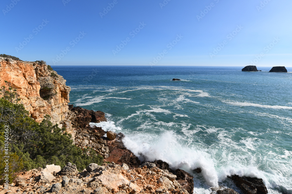 Waves hitting the base of the cliffs on the western Algarve in Portugal
