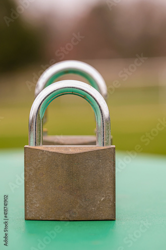 Two heavy duty pad locks displayed, one behind the other. Both are captured in a shallow depth of field.