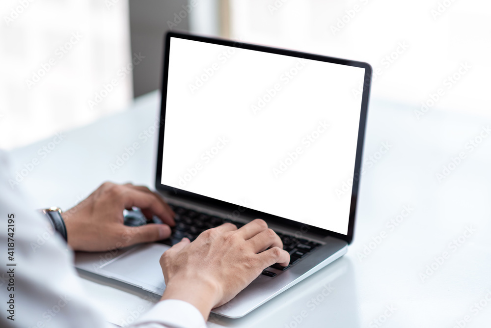 Mock up. Man using laptop white blank screen table at office. Mock up. Man using laptop white blank screen table at office.