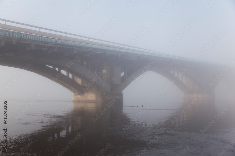 A bridge over a large river.. Fog on the river in early spring A bridge over a large river.. Fog on the river in early spring