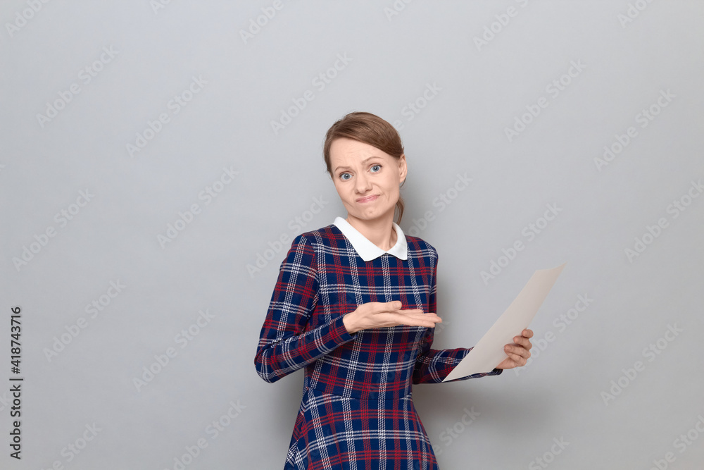Portrait of disgruntled disappointed young woman pointing at document Portrait of disgruntled disappointed young woman pointing at document