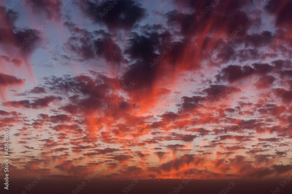 traumhafter Anblick eines Abendhimmels in verschiedenen Rottönen und vielen kleinen Wolken traumhafter Anblick eines Abendhimmels in verschiedenen Rottönen und vielen kleinen Wolken
