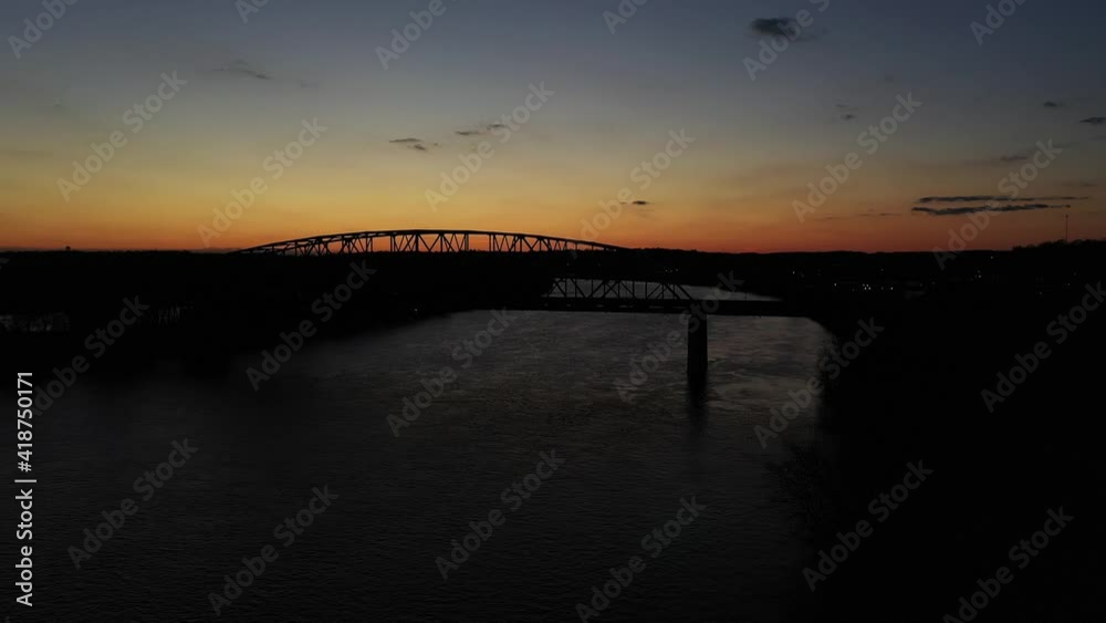 Sunset with amazing colors behind a black silhouettes of a arch steel bridge over a river on a bright day in the USA Slowly dolly drone shot Sunset with amazing colors behind a black silhouettes of a arch steel bridge over a river on a bright day in the USA Slowly dolly drone shot