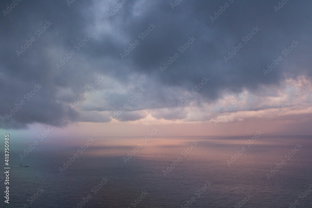 evocative image of clouds seen from an airplane with the sea in the background