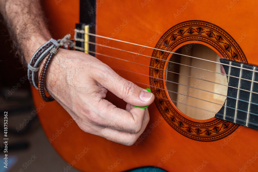 Fototapeta premium Man playing classical guitar with a plectrum Conceptual of music, hobby