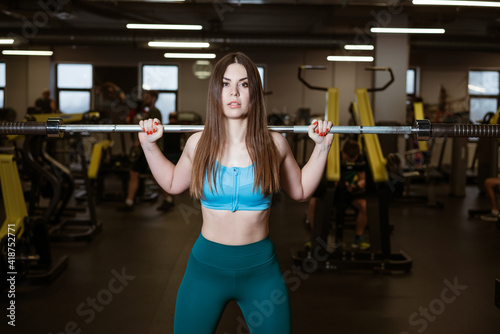 young woman in sportswear is engaged in the gym on simulators