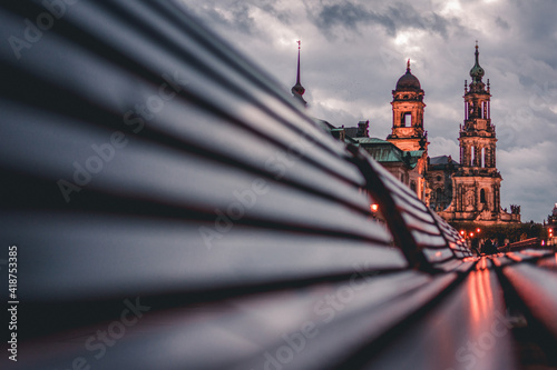 Dresden during blue hour, reflection of sighs on benches at waterfront, Germany