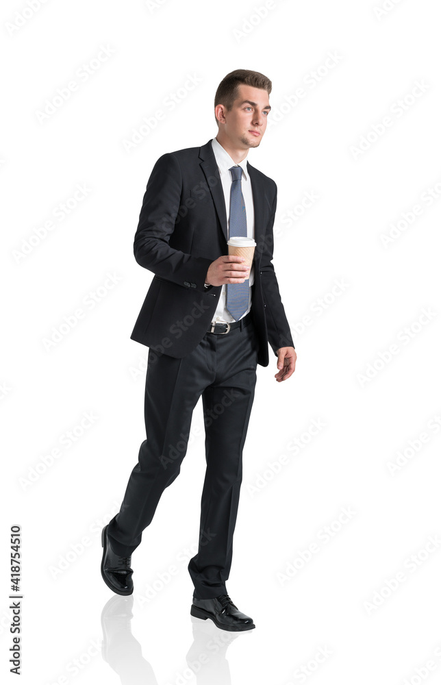 Handsome businessman in formal suit walking with cup of coffee in hands. Isolated on white background Handsome businessman in formal suit walking with cup of coffee in hands. Isolated on white background