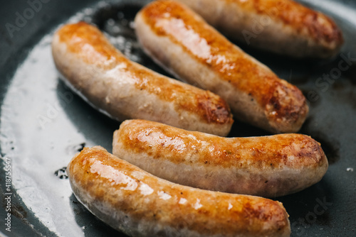 Canvas Print Closeup of Italian sausage links frying in a pan