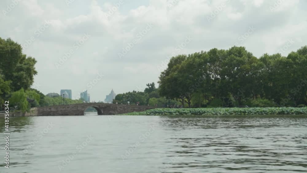 View from the West Lake in Hangzhou China with a bridge and the city in the background View from the West Lake in Hangzhou China with a bridge and the city in the background