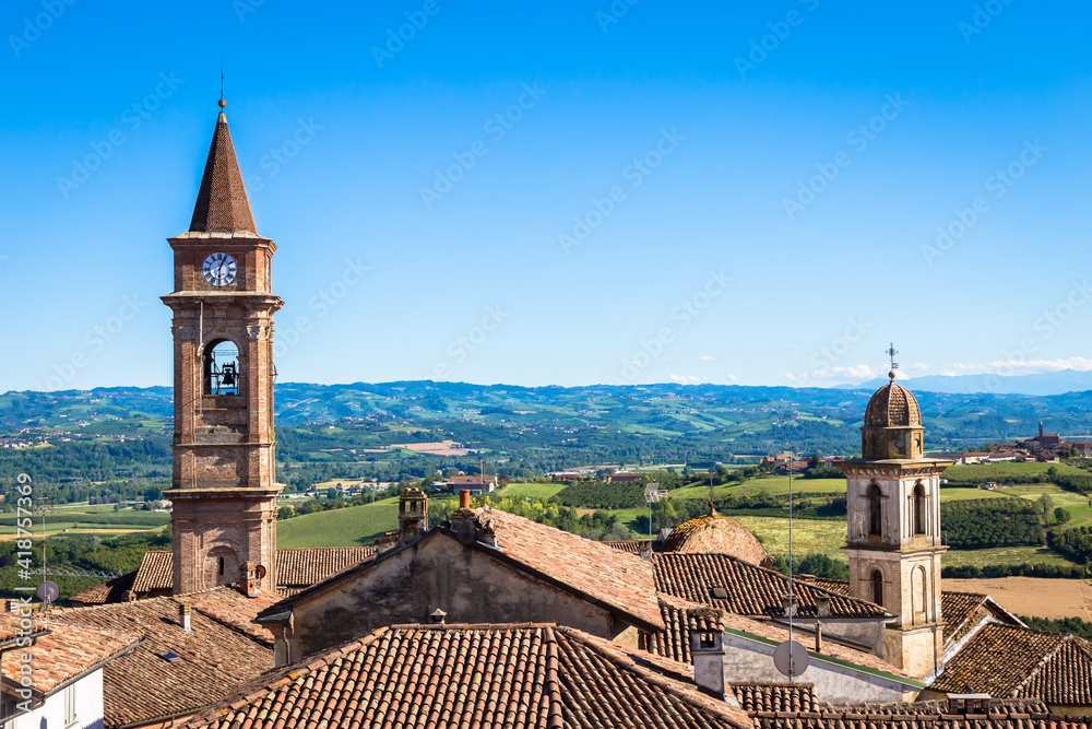 Piedmont hills in Italy with scenic countryside, vineyard field and blue sky. Govone bell tower on the left.