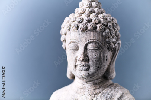 Meditating Buddha Statue on bright wooden background. Copy space.	