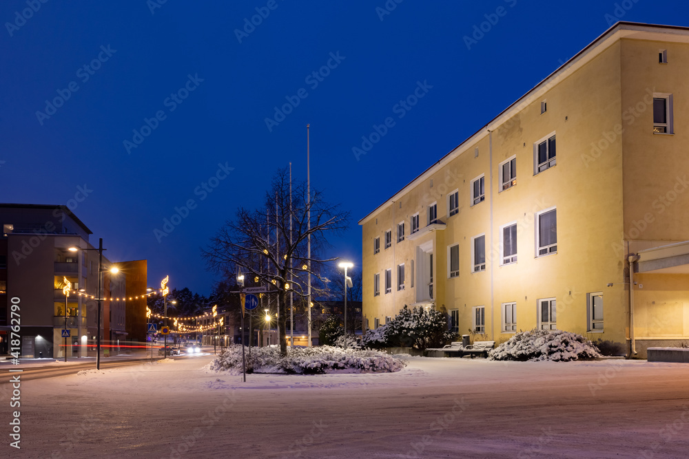 Yellow city hall of a small town at winter night