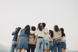 Picture from behind view of groups of friends embrace each other together. Concept for kindness support of people having fun with diversity millenials of gen z.