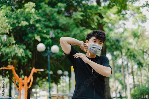 Asian man wear mask that protect against covid 19 warming up for health in the park