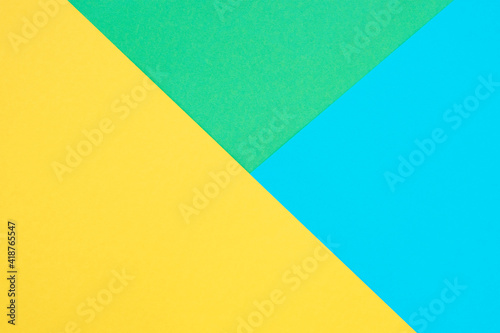 Green, yellow and blue colored paper. Geometric empty paper background, copy space