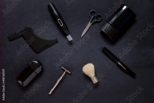 Top view of various men shaving accessories and body care on black background