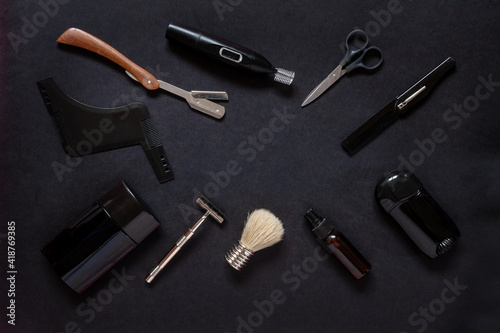 Top view of various men shaving accessories and body care on black background