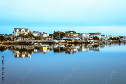 Houses on the west side of Lumina Ave reflecting in the water of the Banks Channel. photo