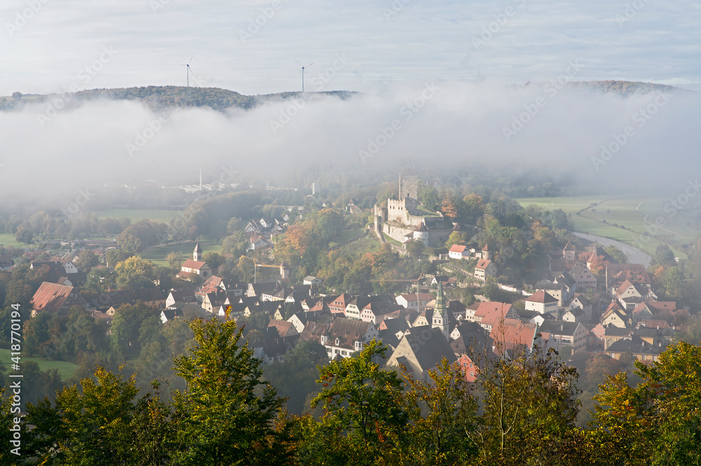 Fog over the city and the castle at sunrise, fall season