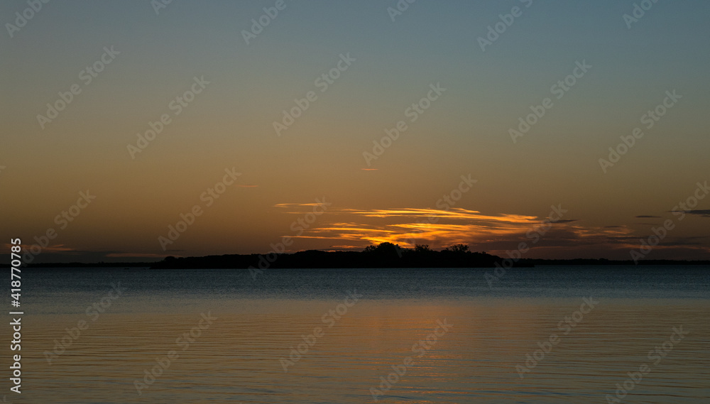 Fototapeta premium El sol se puso tras la isla en playa Seré, Carmelo