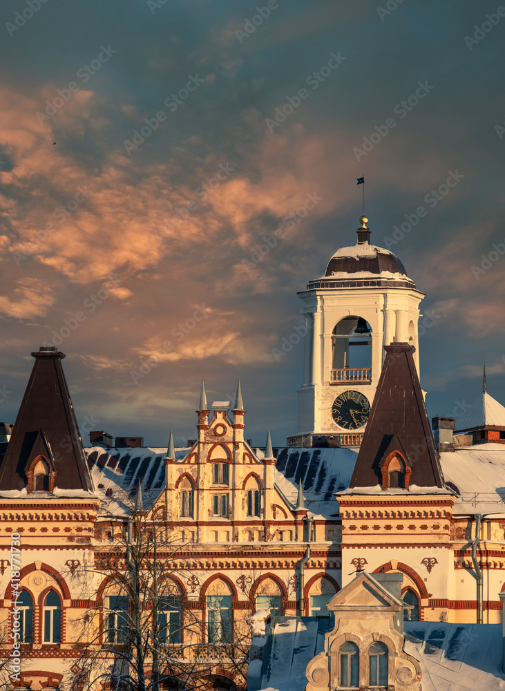Fototapeta premium clock tower in the ancient city of Vyborg with beautiful architecture , Russia, in winter colorful sunset