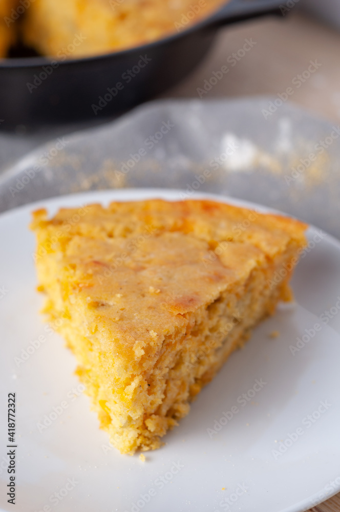 Wedge of cornbread baked in cast iron skillet