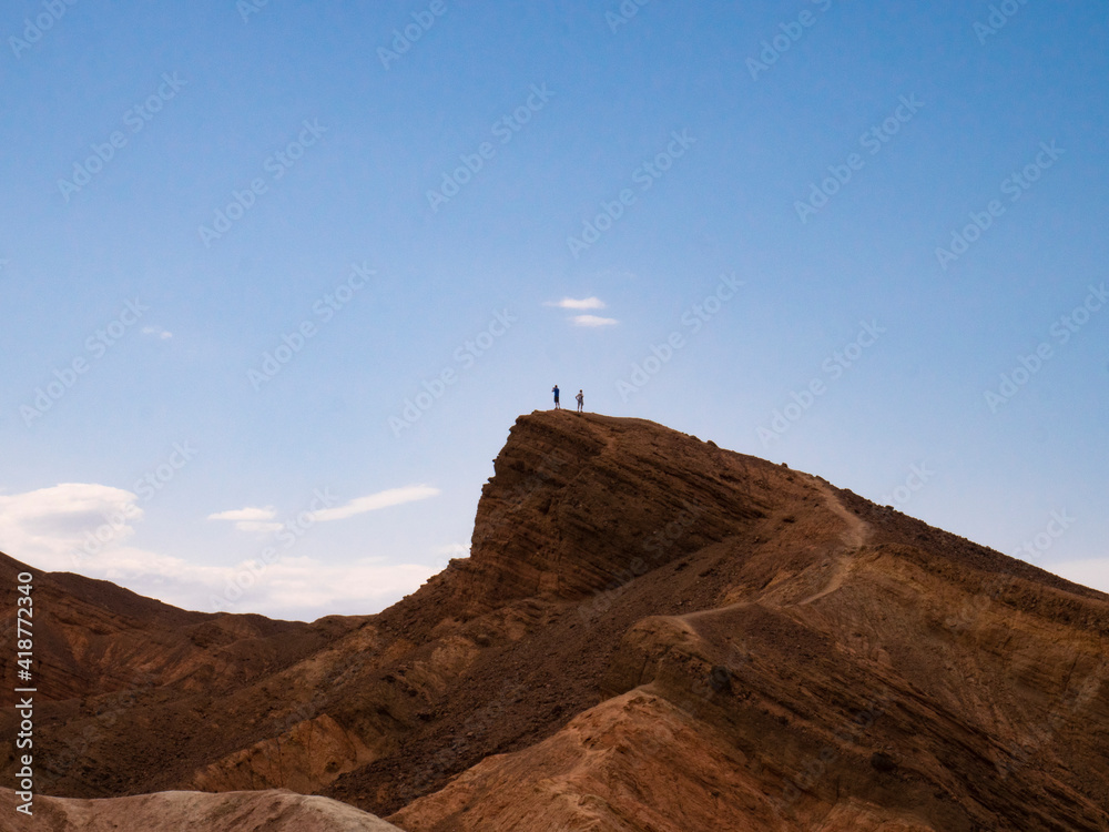 Two Men on the Top of a Mountain in Zabriskie Point, Death Valley, California
