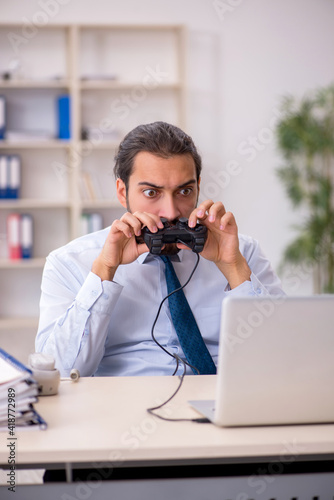 Young male employee playing joystick games during his break © Elnur