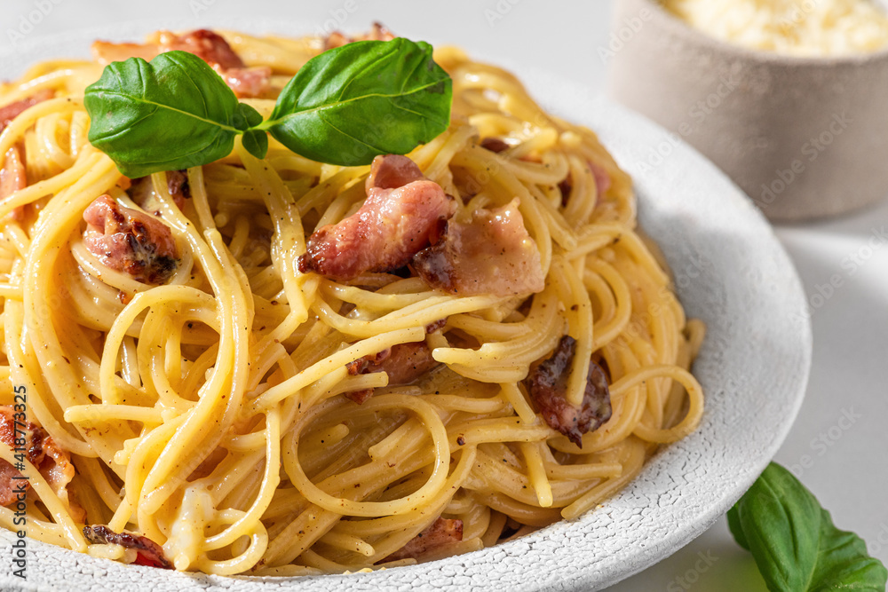 Classic homemade carbonara pasta with pancetta, egg, parmesan cheese, basil and cream sauce. Italian food
