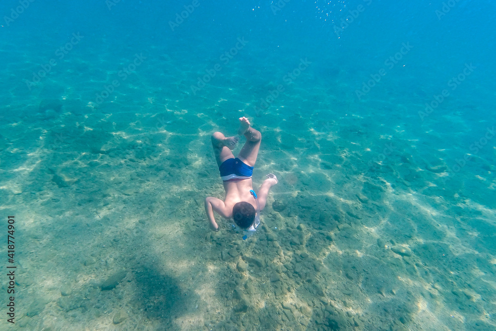 Little kid snorkeling on a clear water