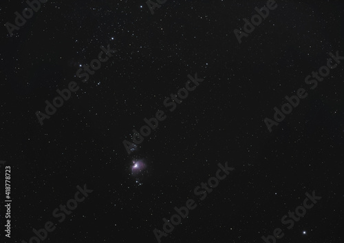 Winter night sky with purple Orion nebula, bright Rigel star in bottom right corner, long exposure photo photo
