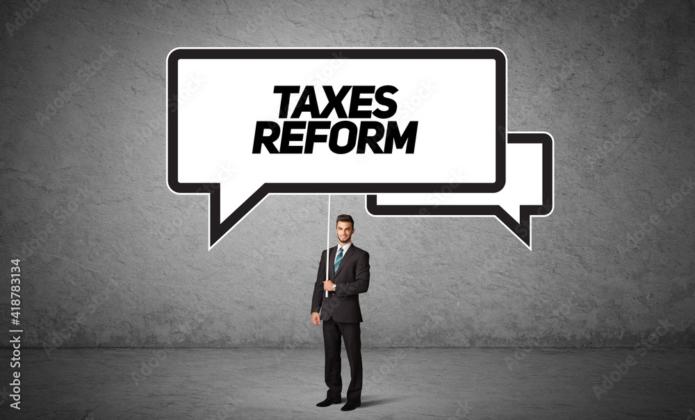 Young business person in casual holding road sign with TAXES REFORM inscription, new business idea concept Young business person in casual holding road sign with TAXES REFORM inscription, new business idea concept