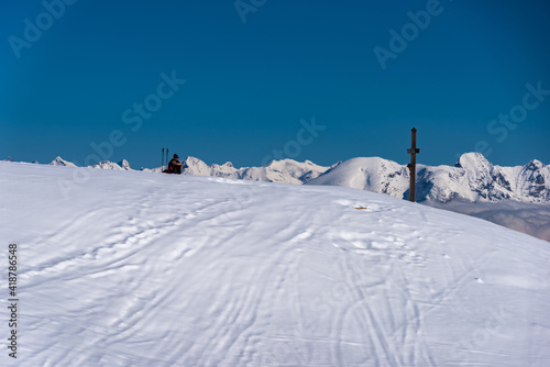 Schneebedeckter Gipfel mit Gipfelkreuz vor blauem Himmel © driendl