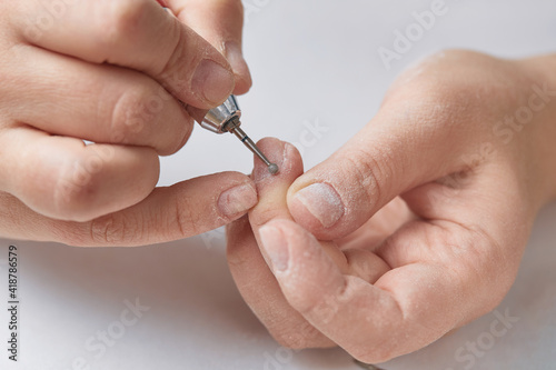 Ball cutter for cuticle treatment during hardware nail manicure. A bit for hardware manicure. Hardware manicure at home. The girl makes herself a hardware manicure at home.