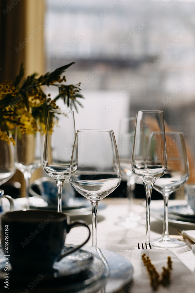 Table setting with wine and champagne glasses in daylight.