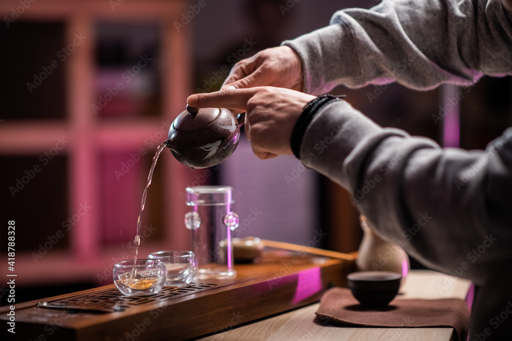 A man treats a guest to authentic ripe vietnamese tea on a special gongfu board made of bamboo. Traditions of eastern tea drinking A man treats a guest to authentic ripe vietnamese tea on a special gongfu board made of bamboo. Traditions of eastern tea drinking