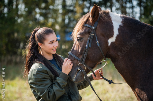 A beautiful girl is happy with her horse and shows her love and tenderness.