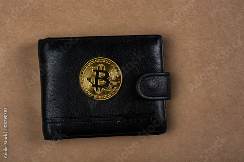 Gold bitcoin on a black men's wallet.