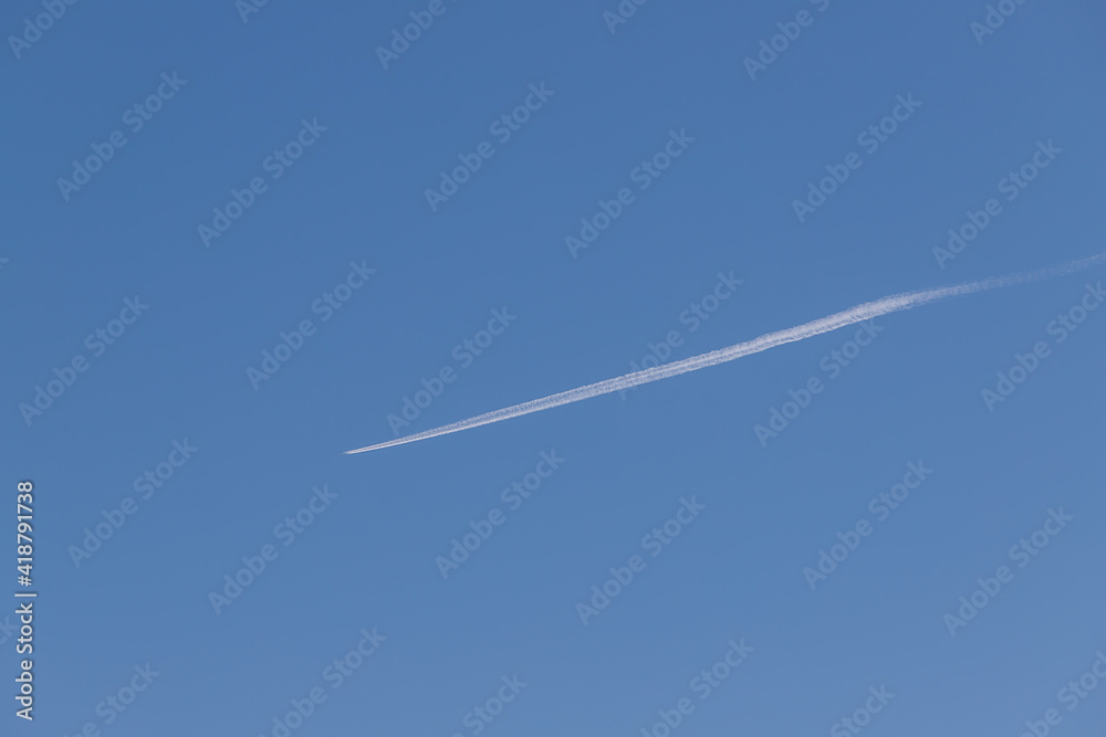 Airliner flies high in the sky. There is a line behind the plane. Airliner flies high in the sky. There is a line behind the plane.