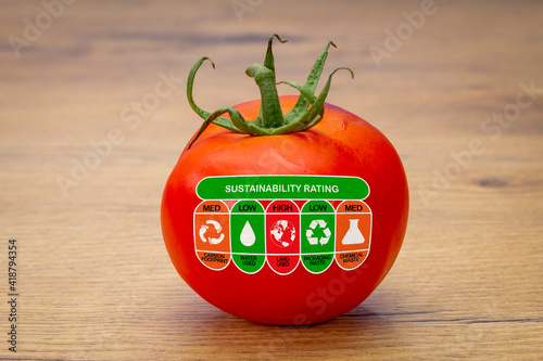 Sustainability Rating label on tomato with high, med and low ratings for food carbon footprint, water use, land use, packaging waste and chemical waste label. Consumer environmental rating label.
